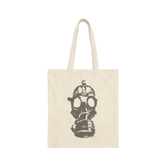 Tan canvas tote bag with large image of gray gas mask in center and handles above, against a white background.