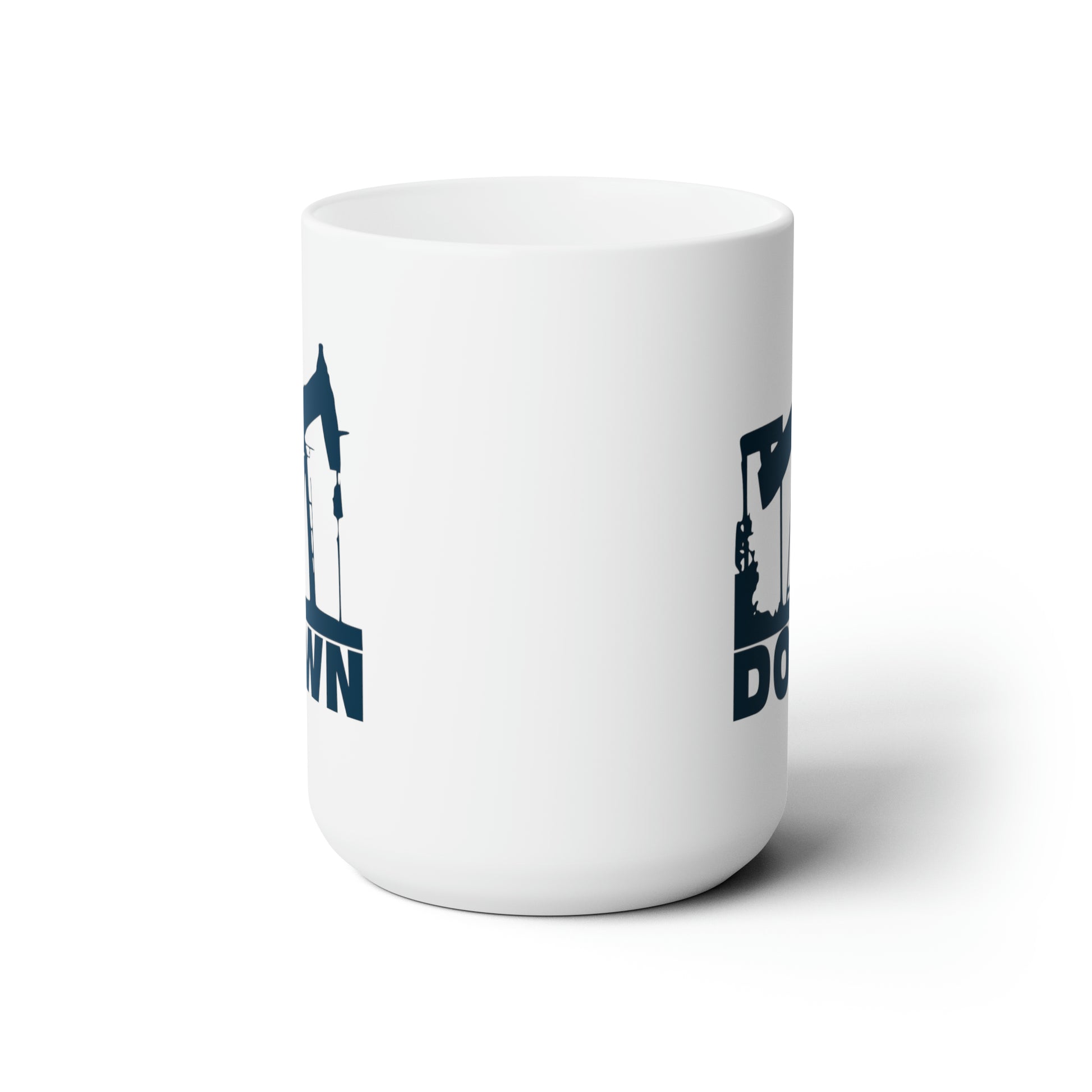 Side view of white coffee mug featuring a navy colored graphic of a drill over the word down, against a white background.