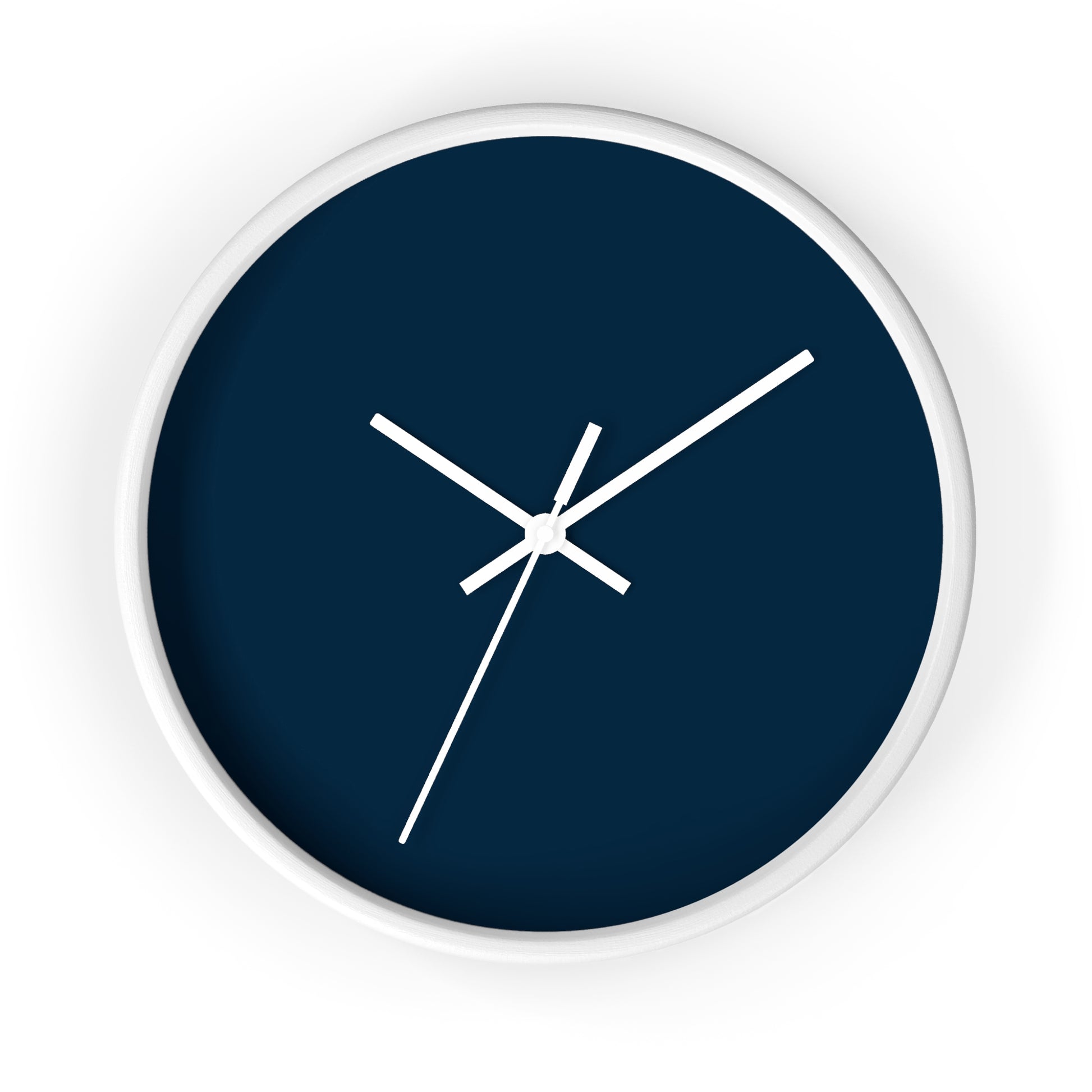 White circular wooden framed clock with navy blue background and white hands against a white background.