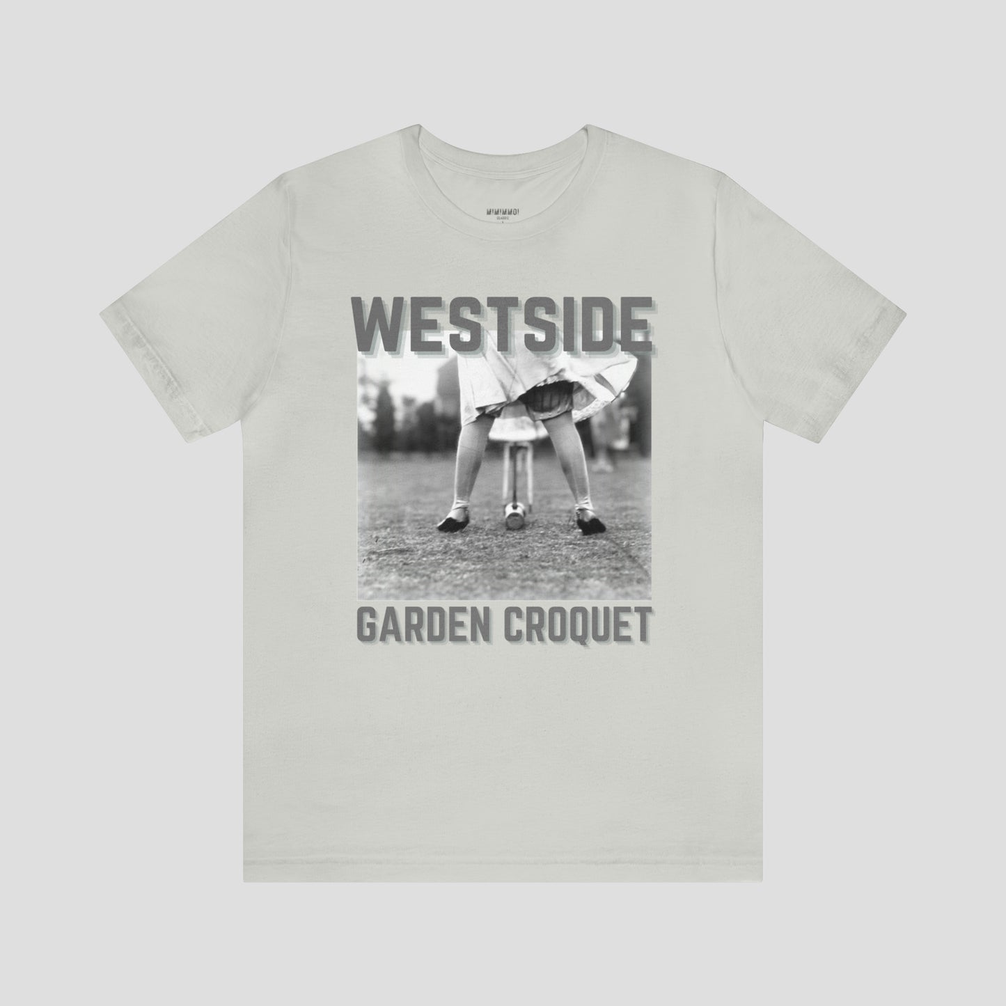 Light-medium gray t-shirt with gray letters and a vintage photo of person bent over playing croquet against a light gray background.