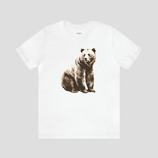 White t-shirt with large bear sitting and looking to the side against light gray background.