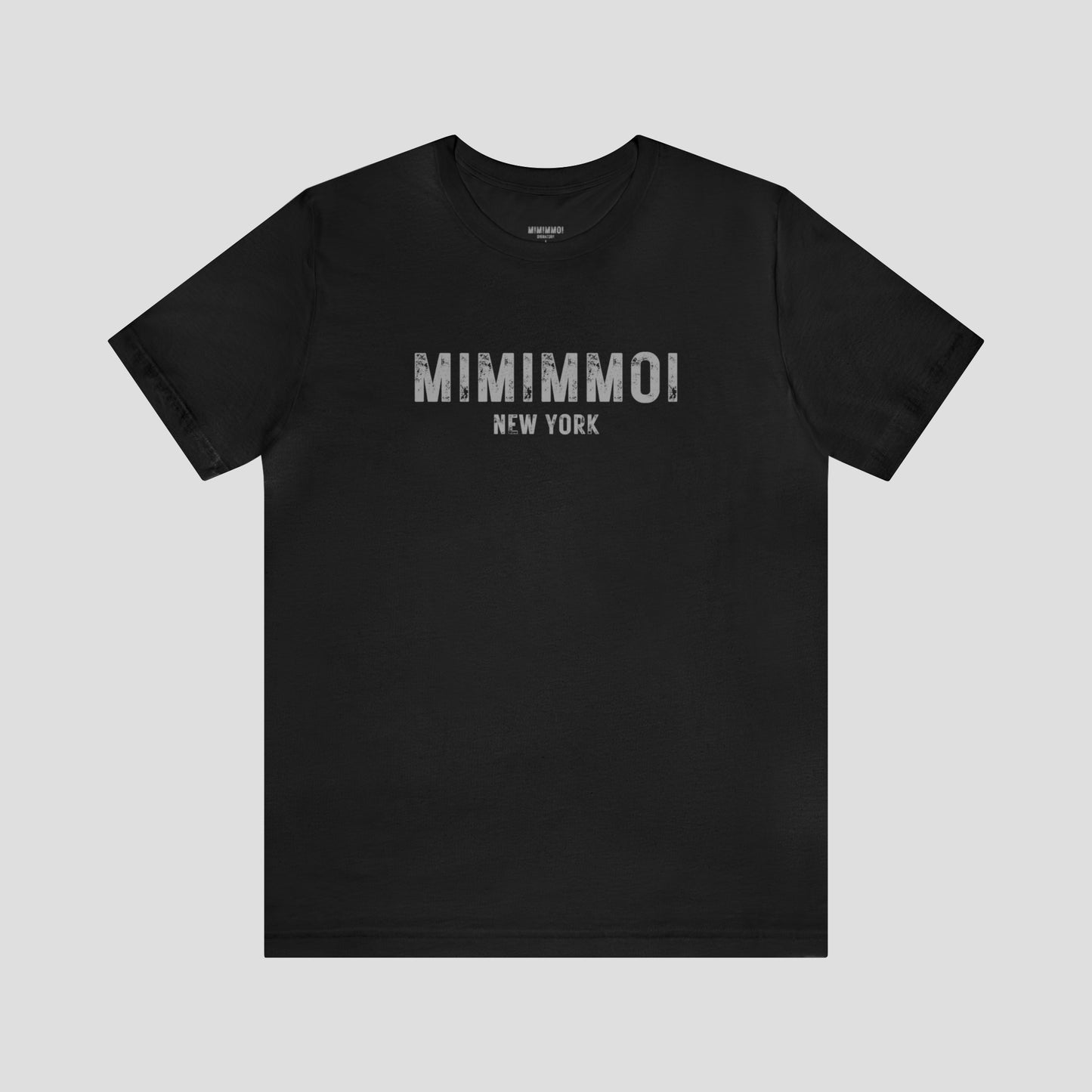 Black t-shirt with the words Mimimmoi New York in distressed gray block letters across the chest, against a gray background.