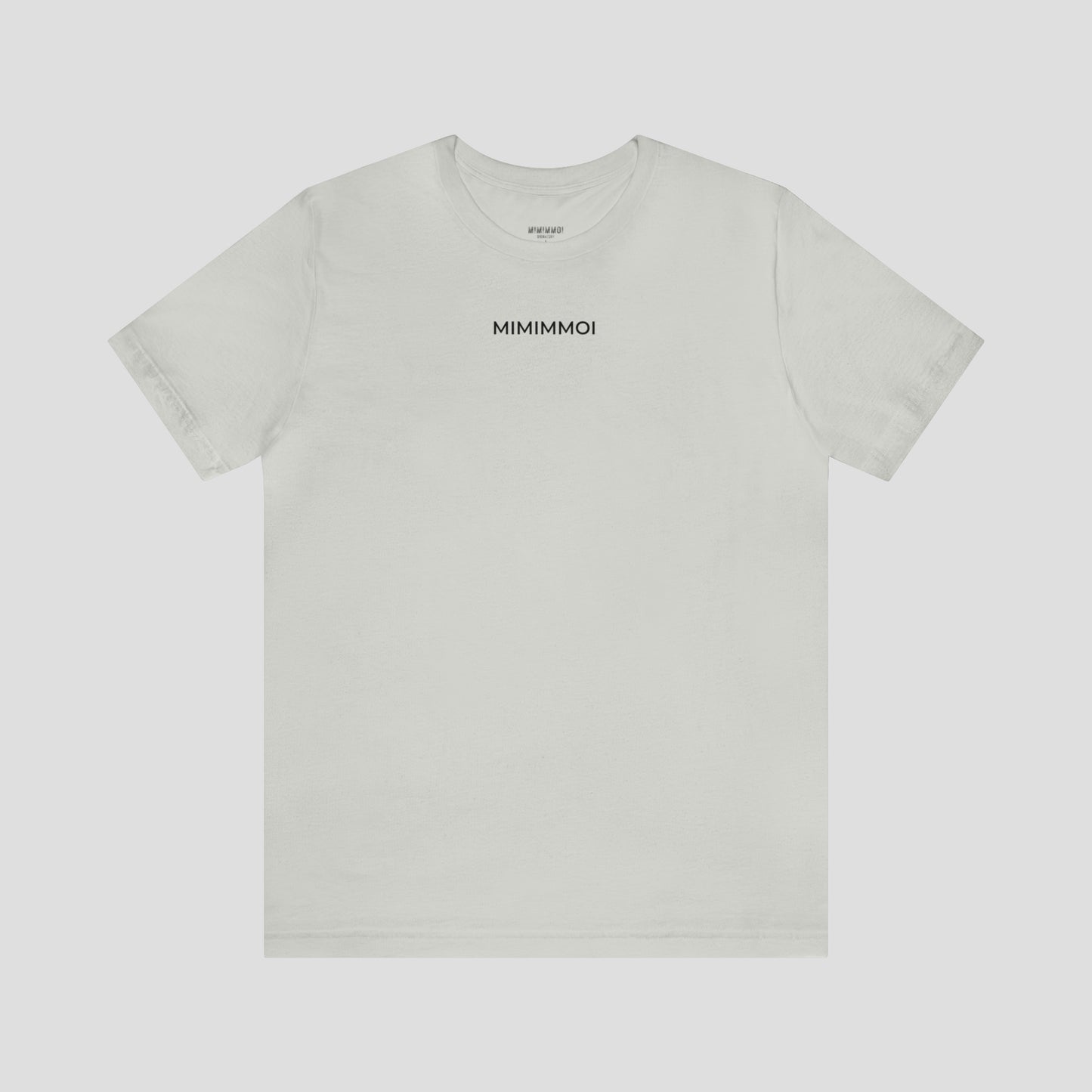 Silver-grey t-shirt with the word "Mimimmoi" in small black letters a few inches under the neckline, against a gray background.