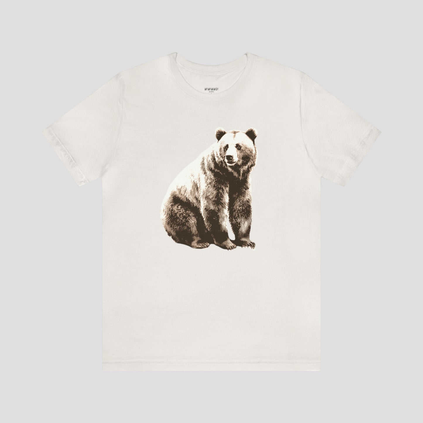 Vintage white t-shirt with large bear sitting and looking to the side against light gray background.