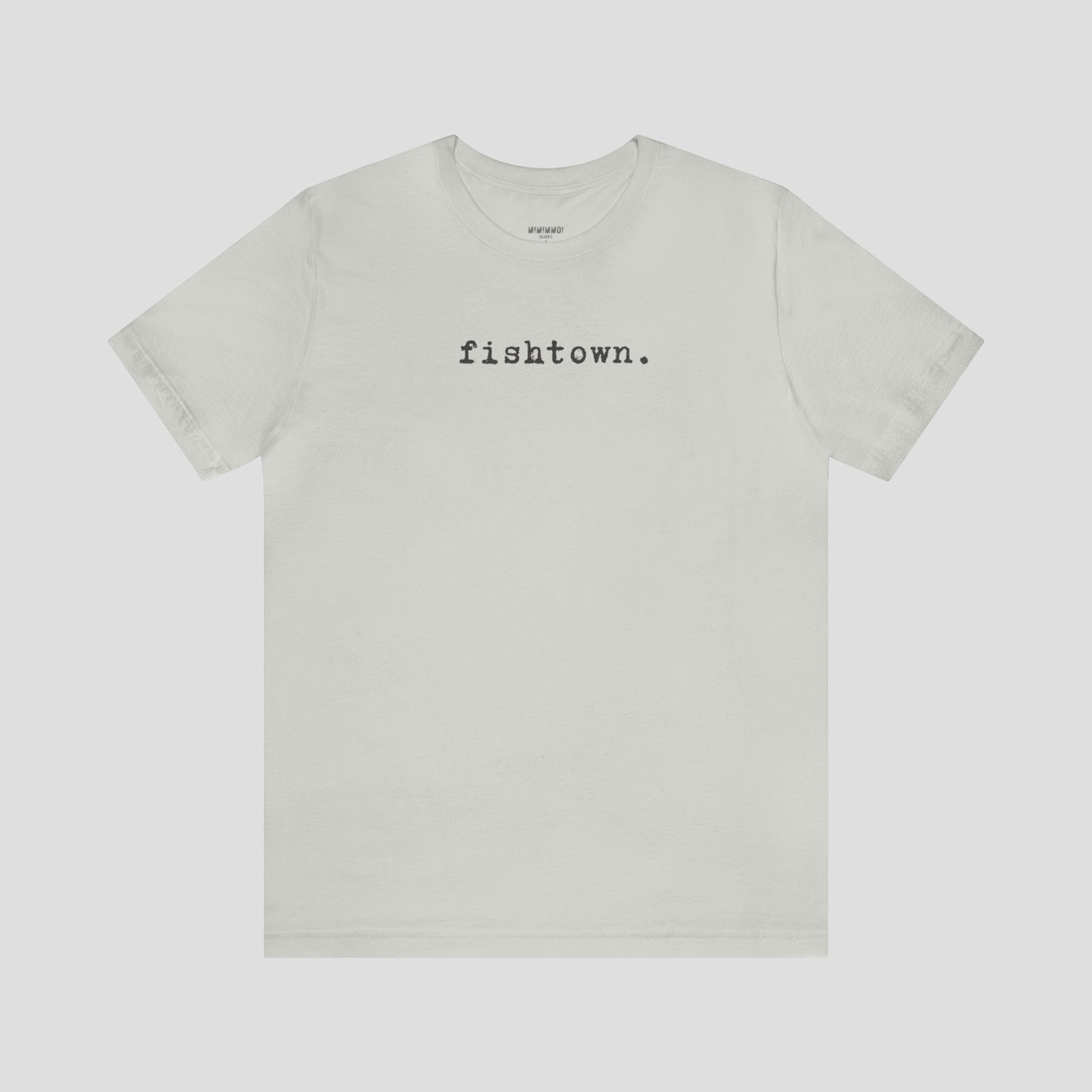 Silver t-shirt with the word Fishtown written in gray typeface font across the chest, against a gray background.