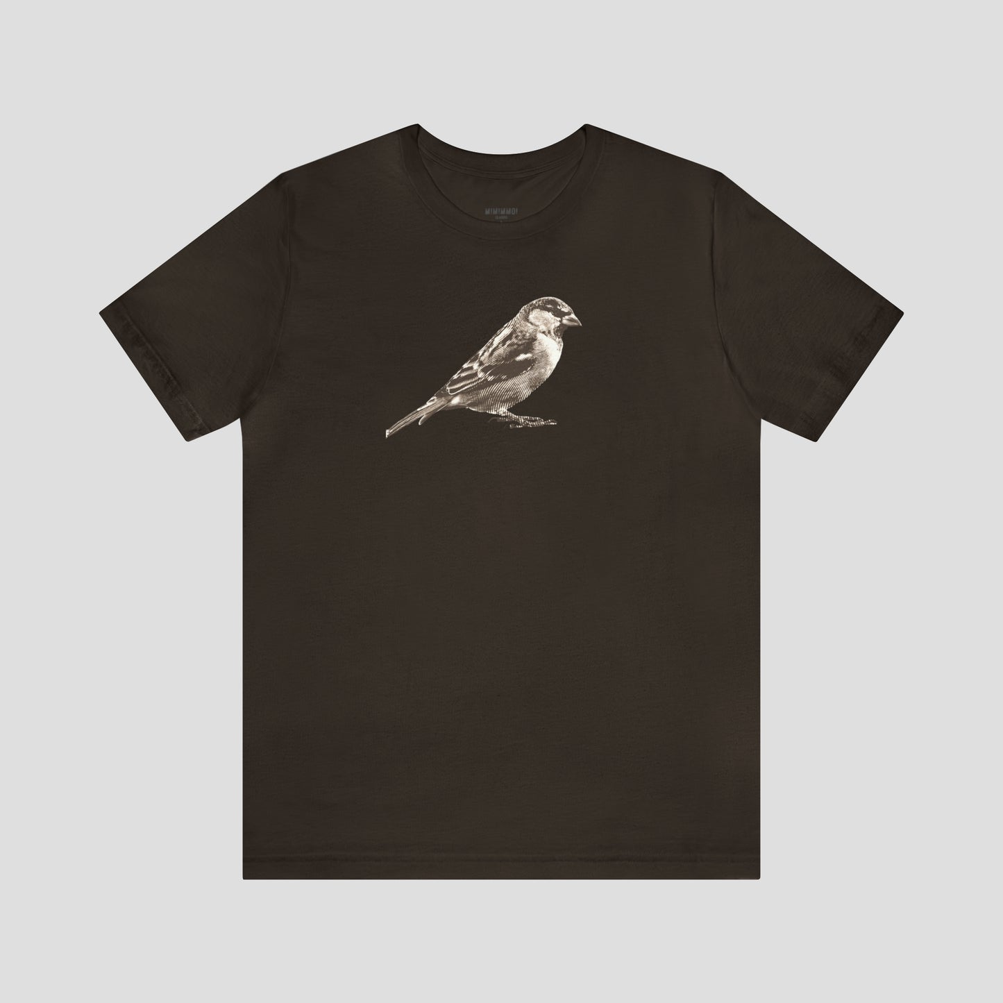 Brown t-shirt with large brown and white illustrated image of a sparrow across the chest, against a gray background.