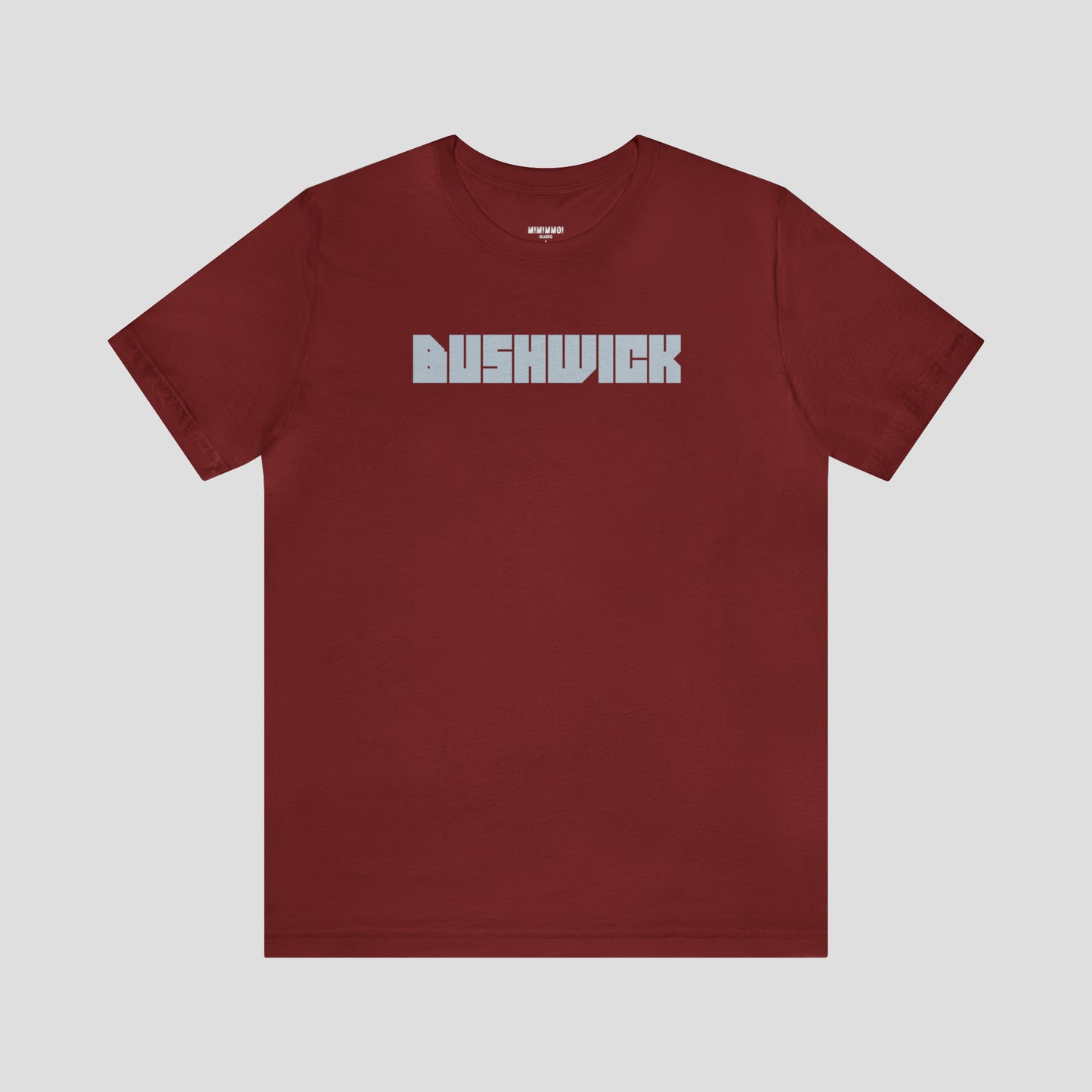 Red t-shirt with "Bushwick" with "Bushwick" in white block letters (in center) against a white background.