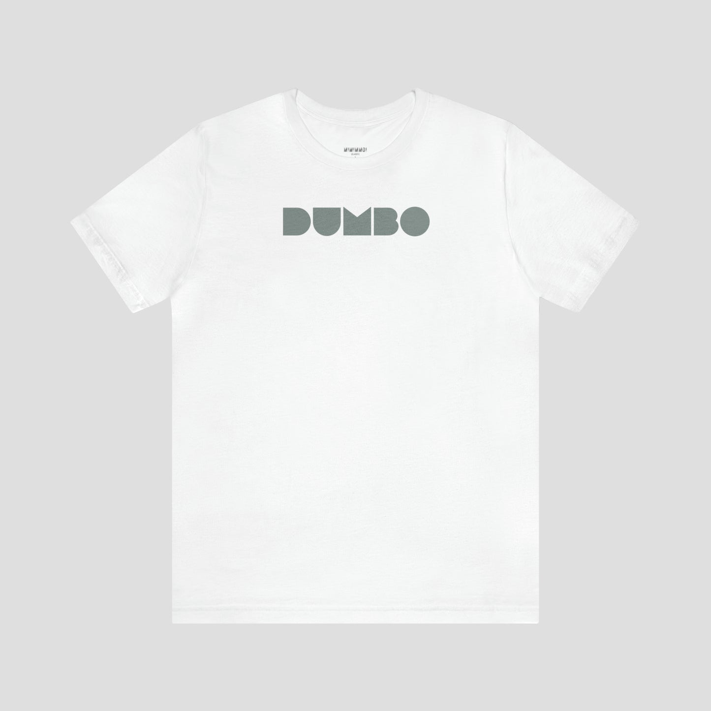 White t-shirt with the word Dumbo in gray block letters across the chest, against a gray background.