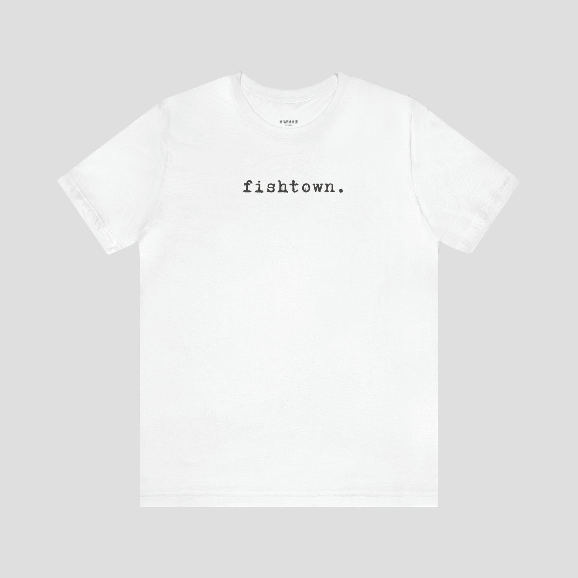 White t-shirt with the word Fishtown written in gray typeface font across the chest, against a gray background.