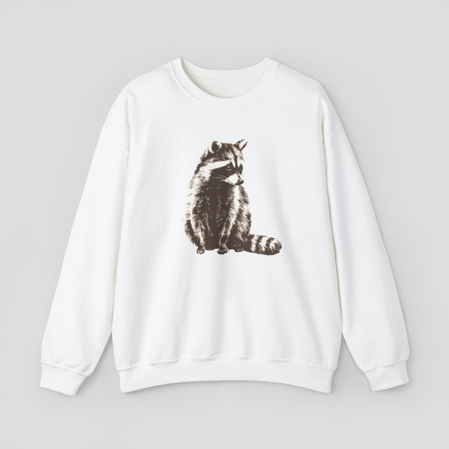 White sweatshirt with large brown and white illustrated image of a racoon across the chest, against a gray background.