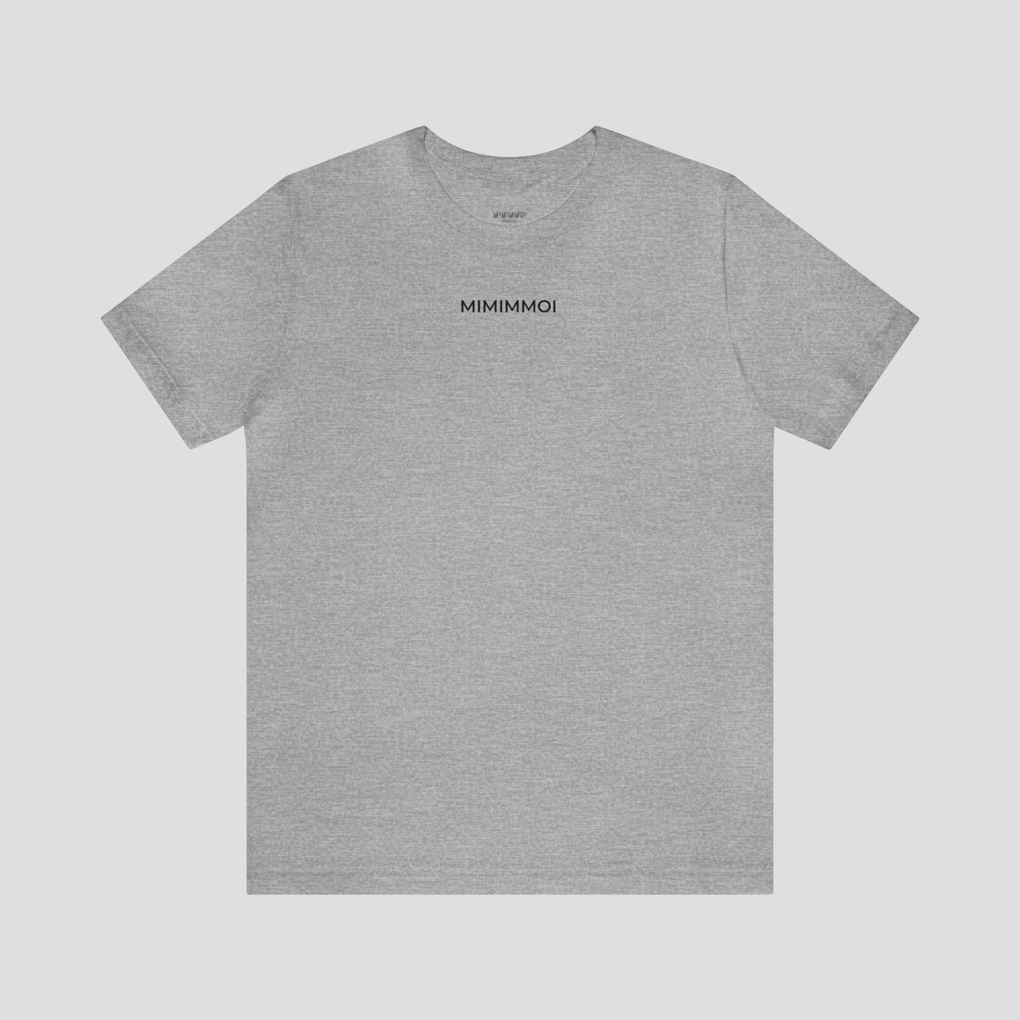 Dark gray t-shirt with the word "Mimimmoi" in small black letters a few inches under the neckline, against a gray background.