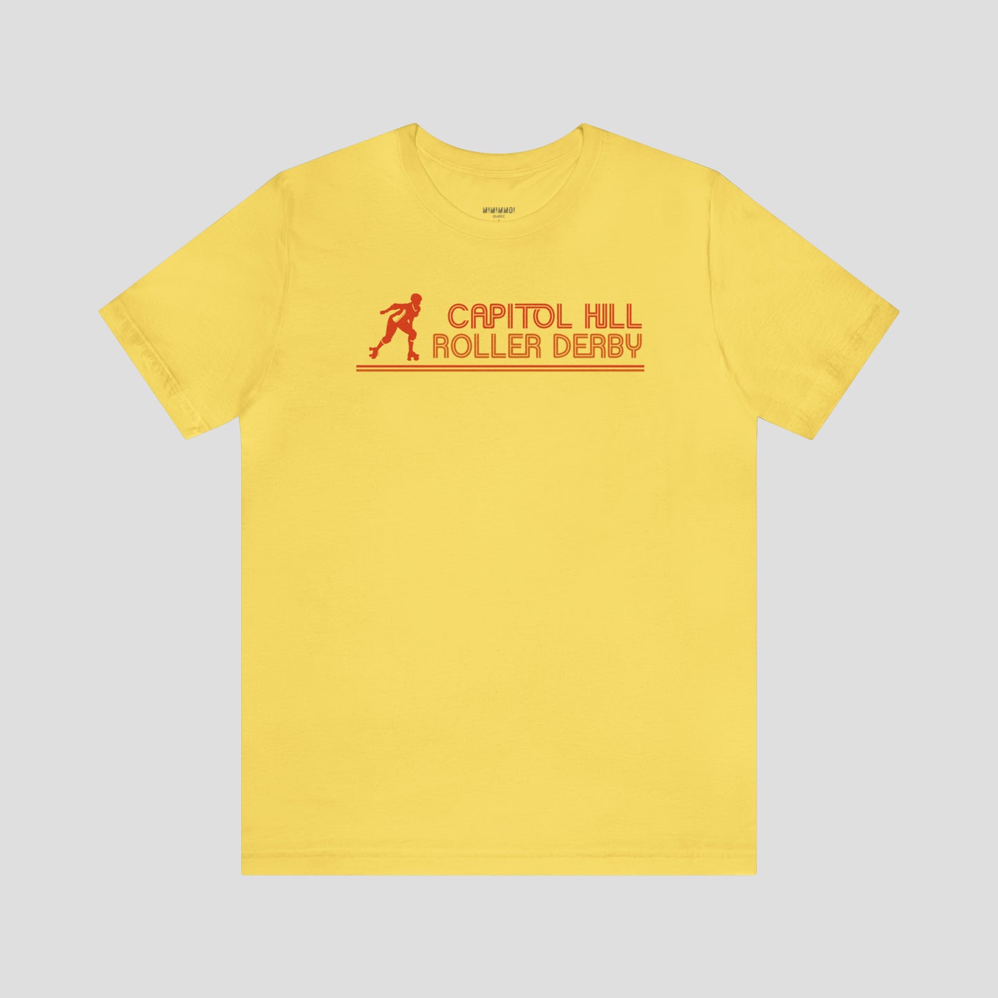 Yellow t-shirt with the words "Capitol Hill Roller Derby" written in orange, lined font and silhouette image of a roller derby player to the left of the words across the chest, against a gray background.